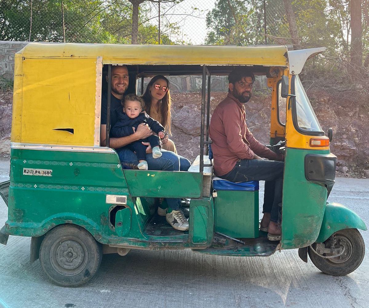 Familia con un bebé en brazos recorriendo Rajastán en tuk-tuk durante un viaje a India en familia