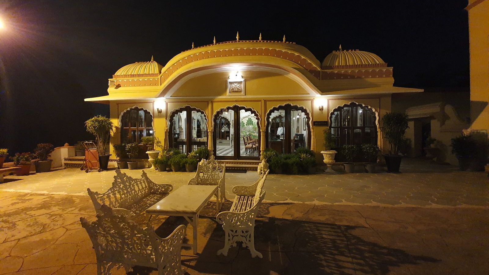 Patio de un hotel de estilo palaciego iluminado al anochecer