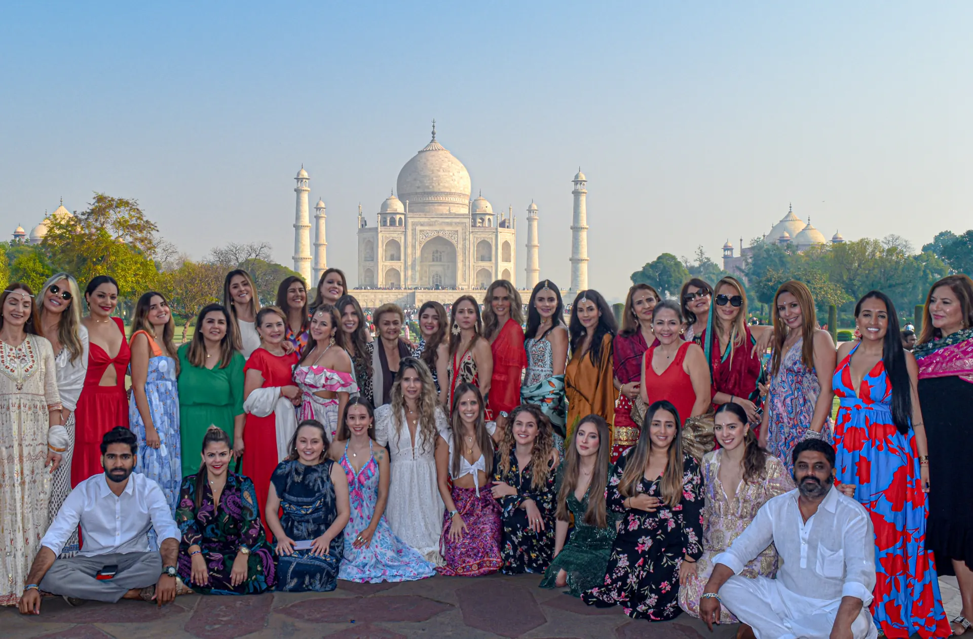 Grupo de viajeras latinoamericanas frente al Taj Mahal al amanecer