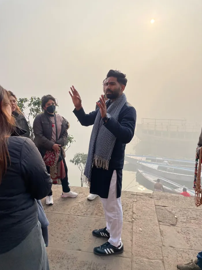 Vijay, fundador de Mariposa Travels, explicando los ghats del Ganges a un grupo de viajeros en Varanasi