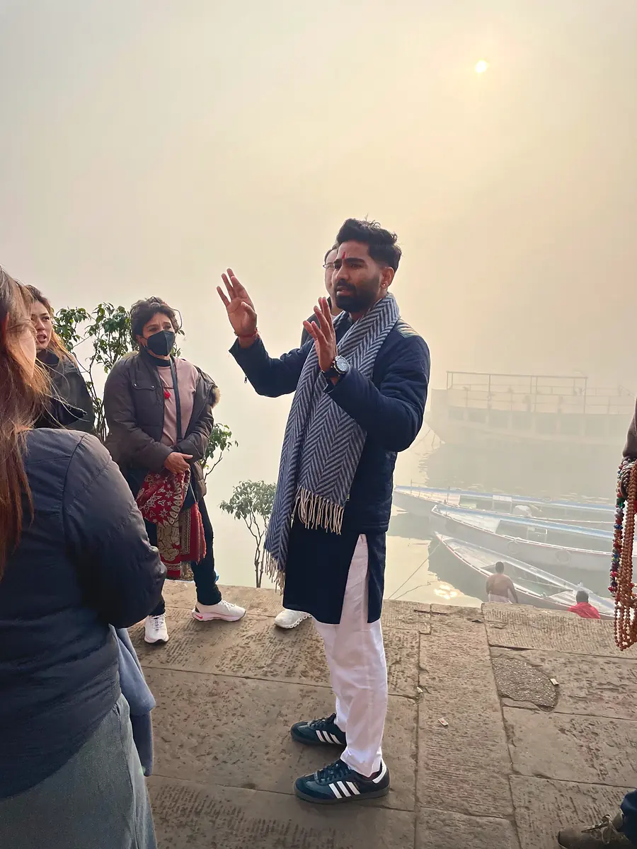 Vijay, fundador de Mariposa Travels, explicando los ghats del Ganges a un grupo de viajeros en Varanasi