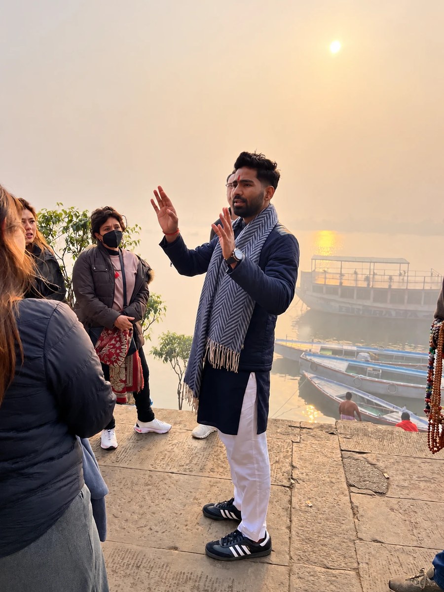 Vijay, fundador de Mariposa Travels, explicando los ghats del Ganges a un grupo de viajeros en Varanasi, al amanecer