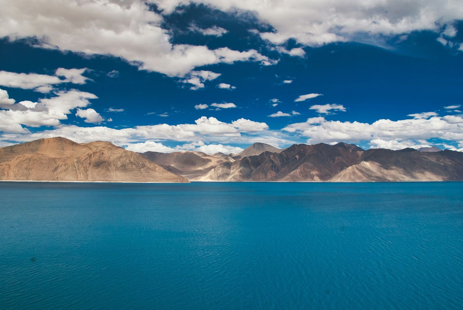 Lago de montaña turquesa en el Himalaya indio, rodeado de cumbres áridas