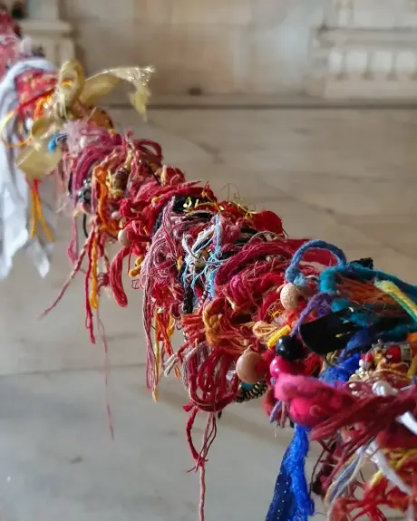 Hilos sagrados atados en la muñeca durante una ceremonia en un templo