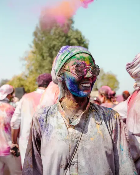 Una viajera sonríe entre el humo rosa de Holi
