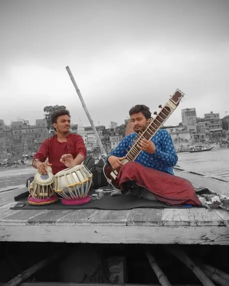 Dos músicos tocan sitar y tabla en una terraza sobre los ghats de Varanasi
