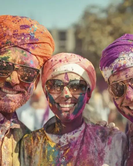 Viajeras con el rostro cubierto de pigmento celebran Holi