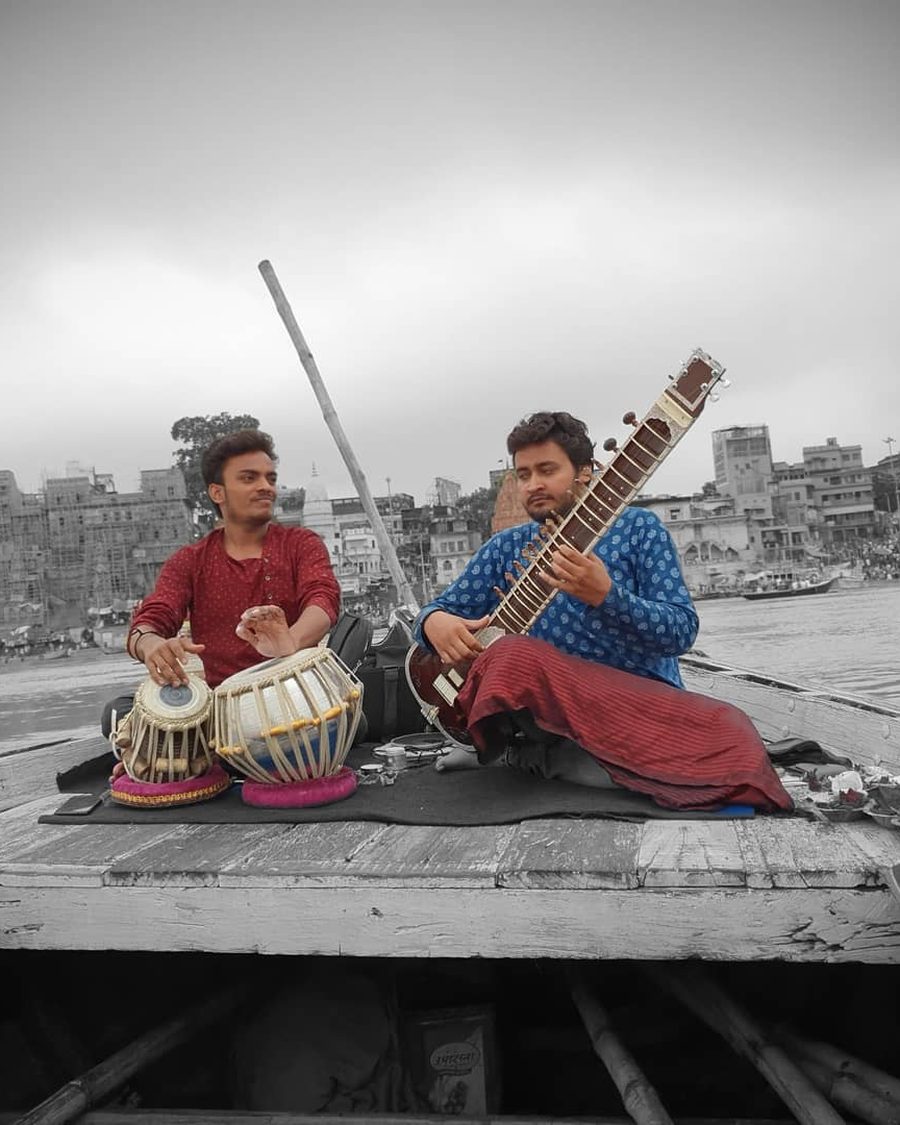 Dos músicos tocan sitar y tabla en una terraza sobre los ghats de Varanasi