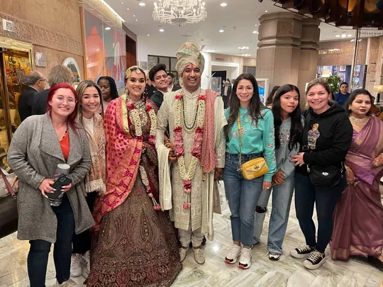 Viajeras de Mariposa Travels posan con los novios en el vestíbulo de un hotel durante una boda india