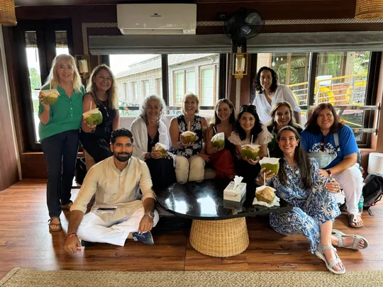 Grupo de viajeras con cocos tiernos en el salón de una casa flotante en el sur de la India