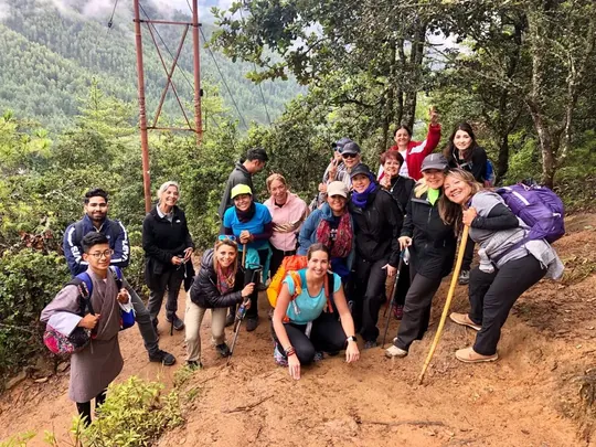 Viajeros con bastones y mochilas durante una caminata por un sendero de montaña en Bután
