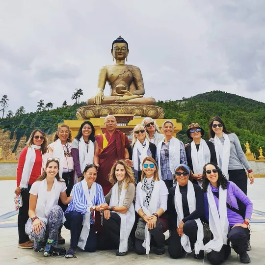Grupo de viajeras con un monje budista ante la gran estatua dorada del Buda Dordenma en Bután