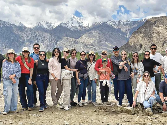 Un grupo de viajeros posa ante las montañas nevadas del valle de Nubra, en Ladakh
