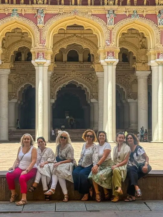 Viajeras sentadas ante las columnas de un palacio del sur de la India