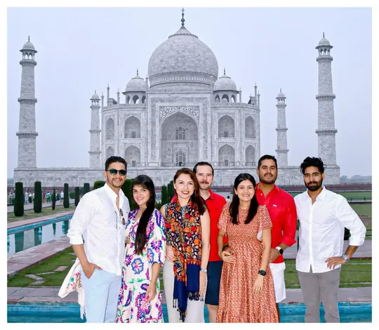 Grupo pequeño de viajeros junto al estanque de los jardines del Taj Mahal, en Agra