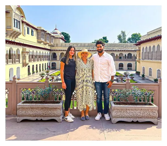 Tres viajeros posando en el patio de un palacio durante un viaje privado por la India