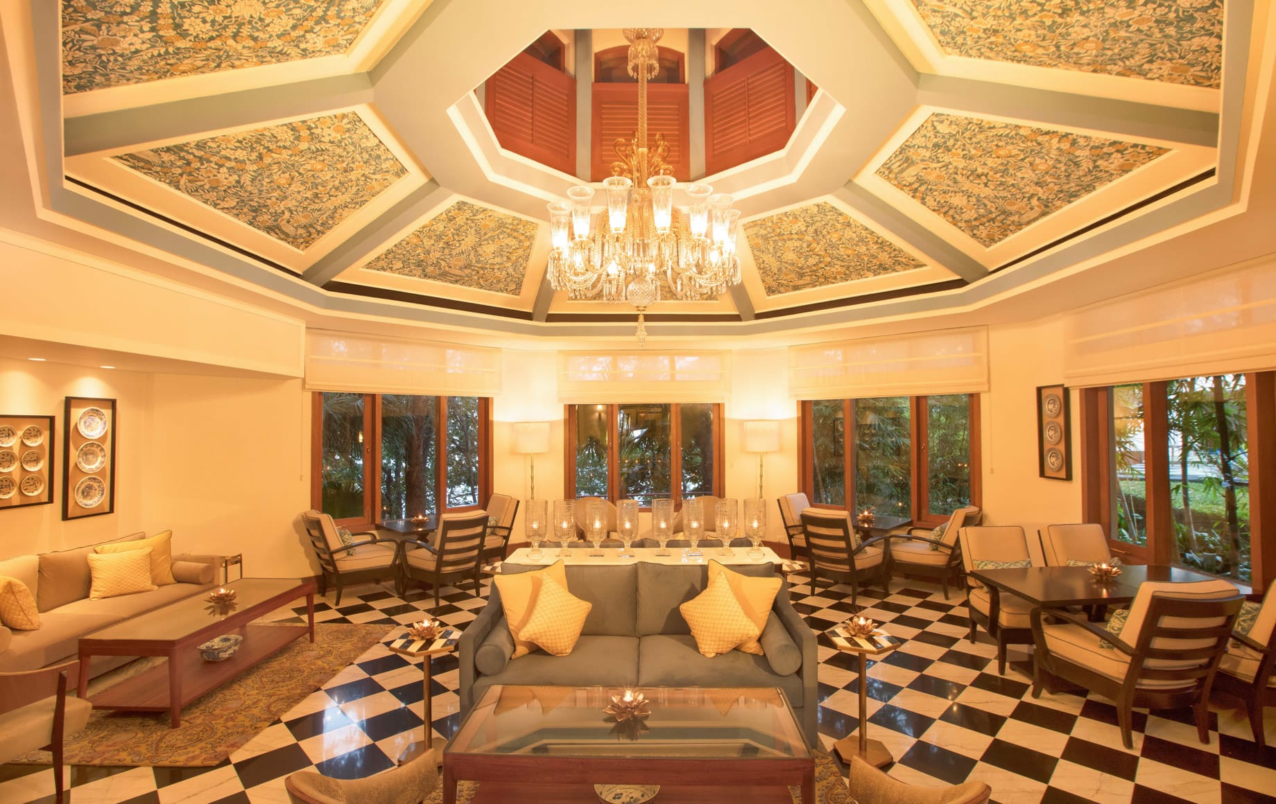 Salón de un hotel palacio en la India con candelabro de cristal y suelo de mármol ajedrezado