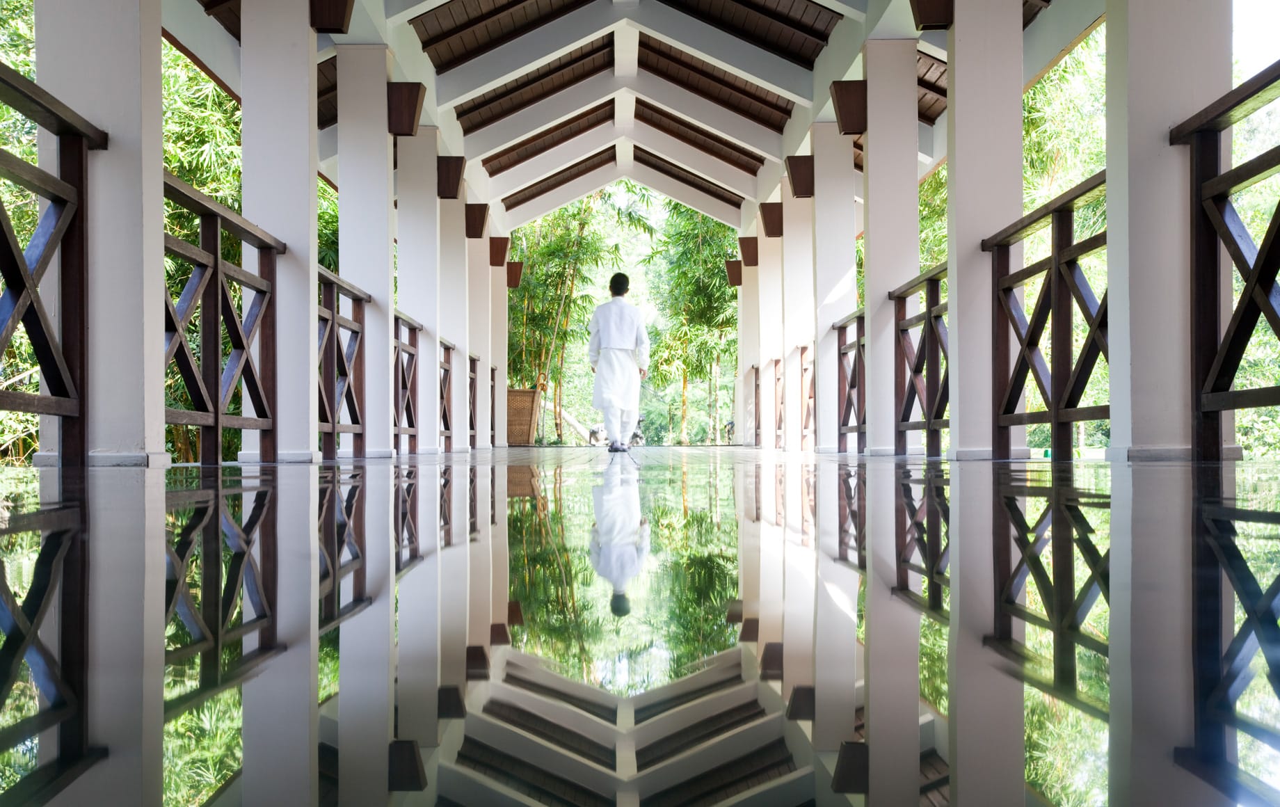 Pasillo de un hotel de bienestar en la India reflejado en un estanque de agua
