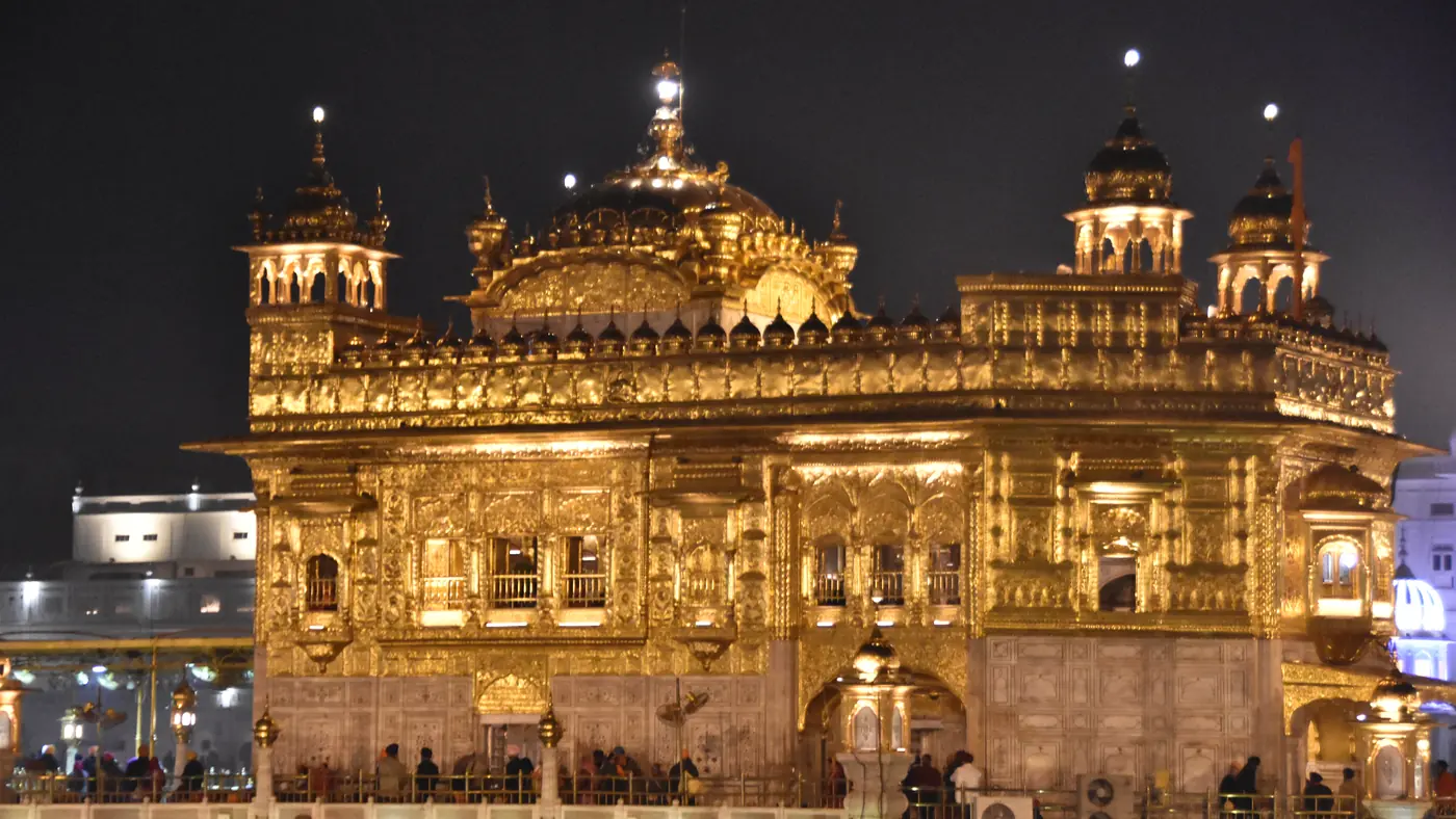 El Harmandir Sahib iluminado de noche sobre el Amrit Sarovar