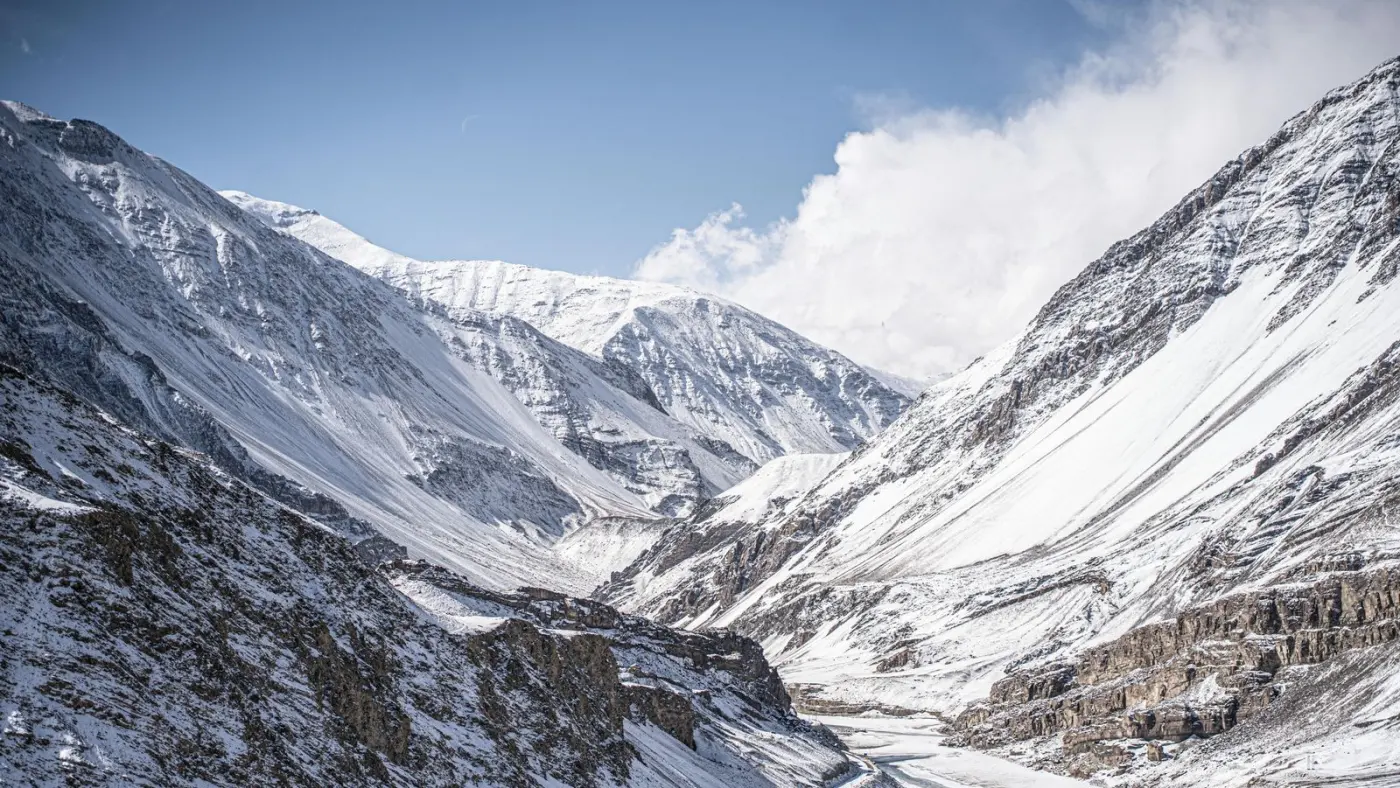 Crestas nevadas y un río helado en un valle de altura de Ladakh