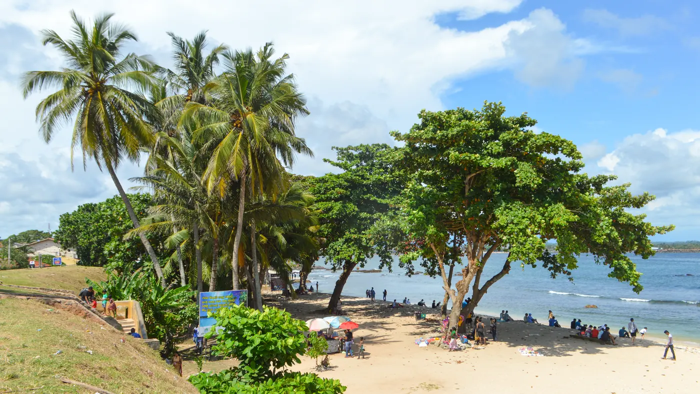 Playa de palmeras junto al fuerte de Galle, en la costa sur