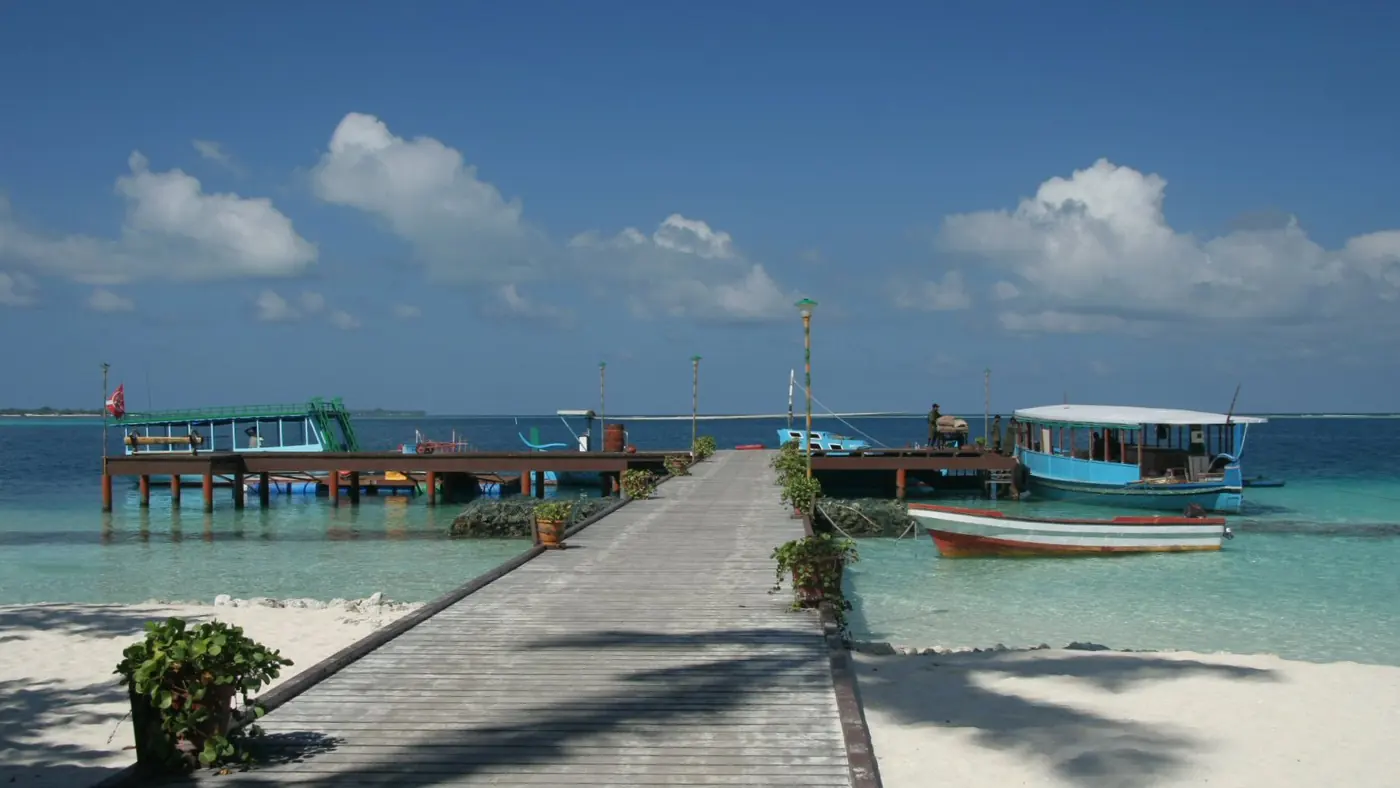 Embarcadero y dhonis de madera en una isla habitada de las Maldivas